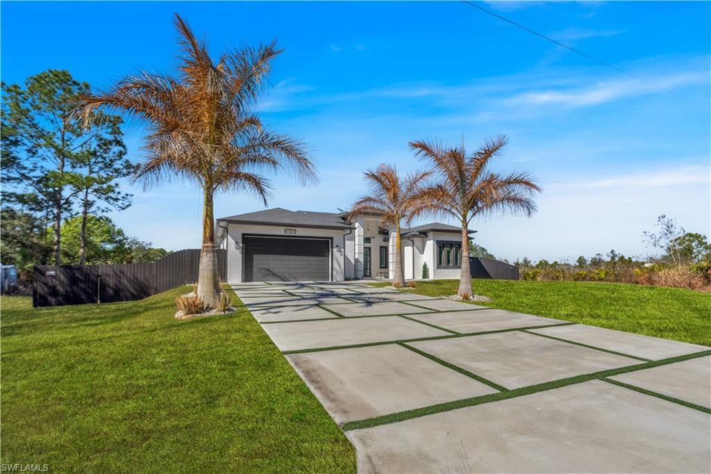 View of front of house featuring driveway, stucco siding, and a garage