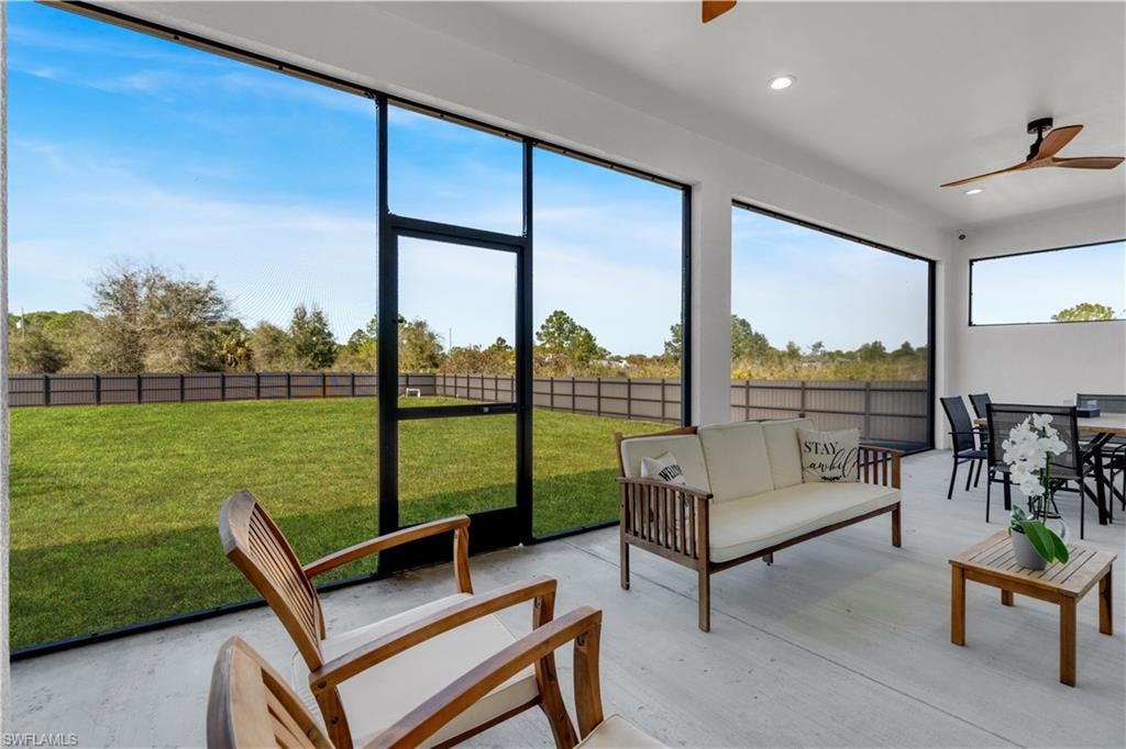 Sunroom with a ceiling fan and outdoor lounge area