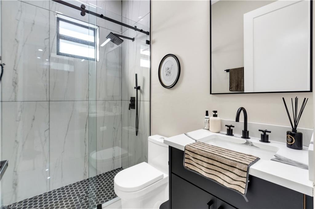 Full bathroom featuring vanity and a marble finish shower