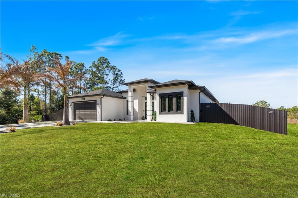 View of front of home featuring stucco siding, an attached garage, a gate, and concrete driveway