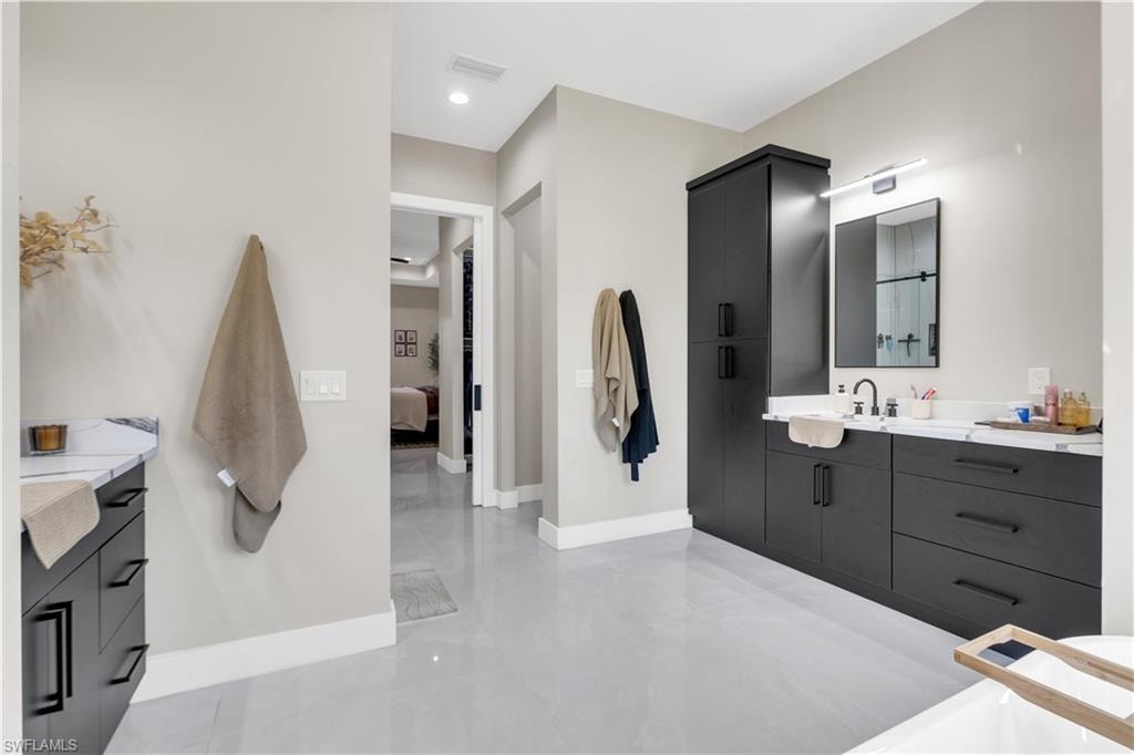 Ensuite bathroom featuring vanity and baseboards