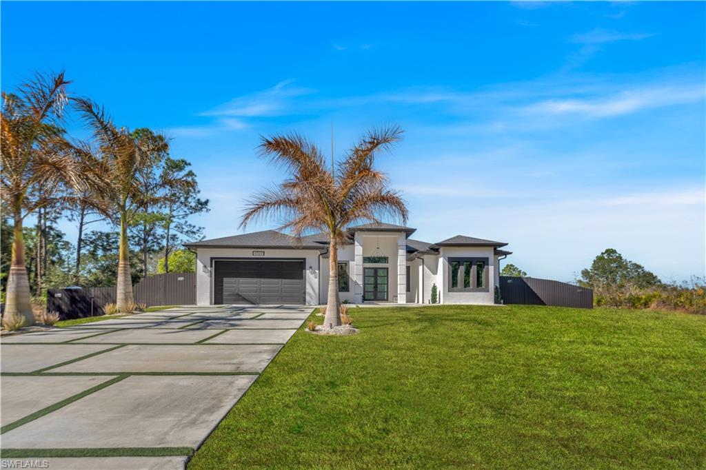 View of front facade featuring concrete driveway, a garage, and stucco siding
