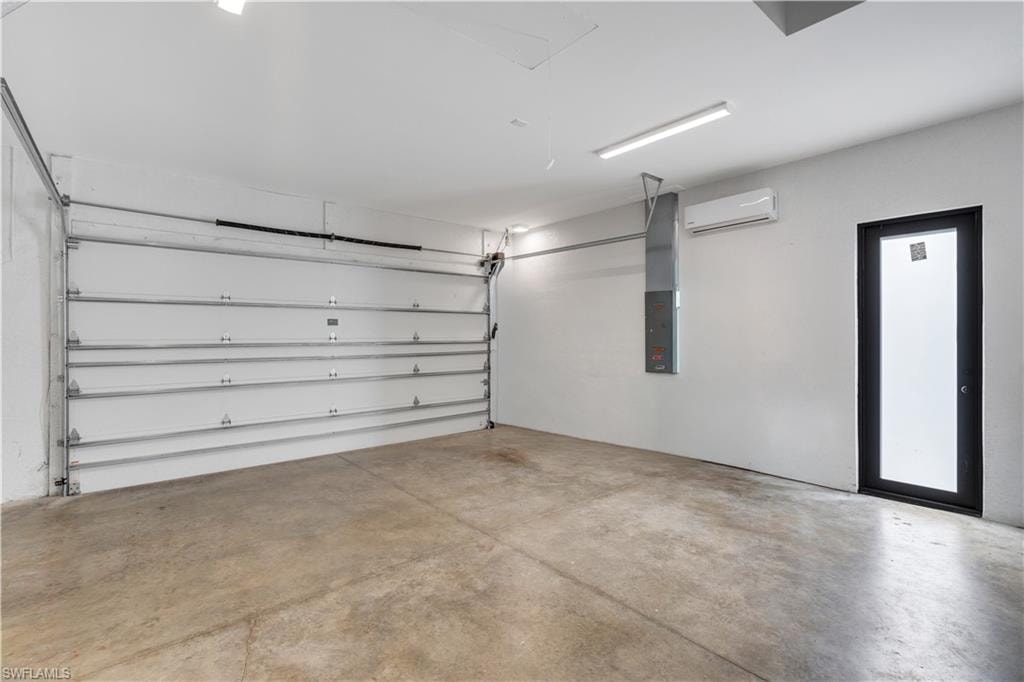 Garage featuring electric panel and a mini split for heating / cooling