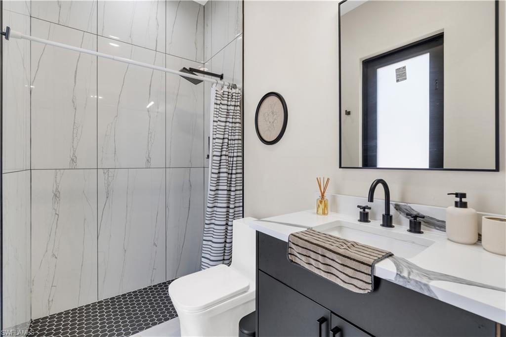 Full bathroom featuring a tile shower and vanity