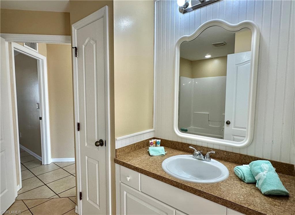 Second Bath J'nJ with Utility Closet, Mirrored Wood Slat Back Wall and Doorway to Third/Front Bedroom and Greatroom