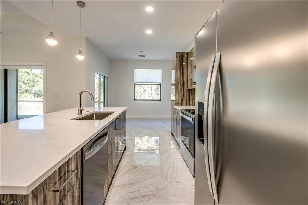 Kitchen featuring modern cabinets, stainless steel appliances, and a large island