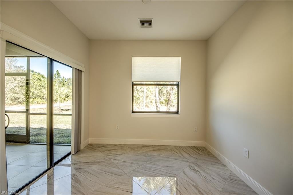 Unfurnished room with baseboards and light marble finish flooring