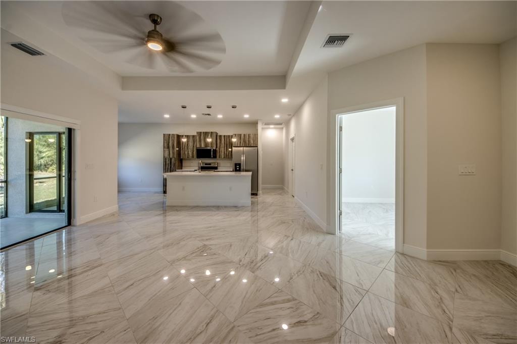 Unfurnished living room with ceiling fan and recessed lighting