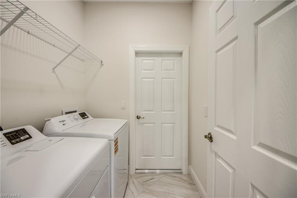 Laundry room with washer and clothes dryer and light marble finish flooring