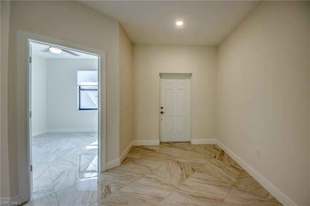 Entrance foyer with baseboards and light marble finish flooring
