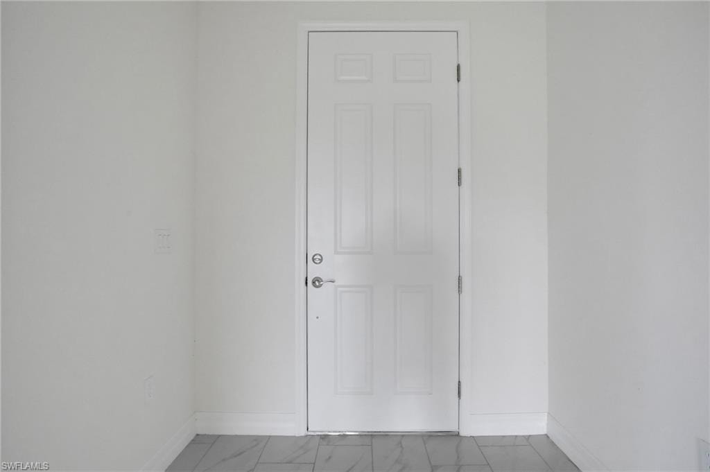 Spare room with baseboards and marble finish floors
