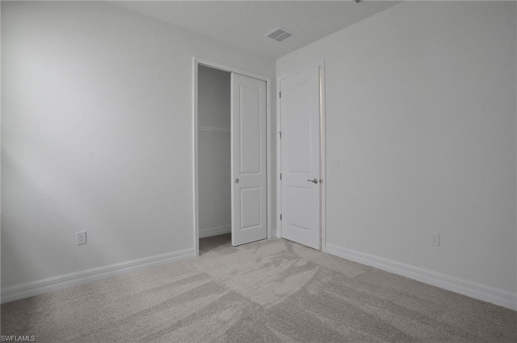 Unfurnished bedroom featuring light colored carpet and a closet