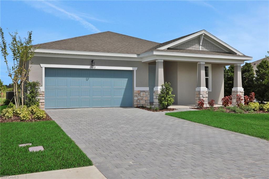 Craftsman inspired home featuring stone siding, stucco siding, covered porch, and a front lawn