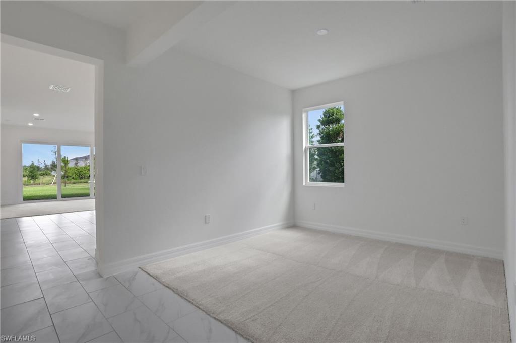 Empty room featuring baseboards and beamed ceiling