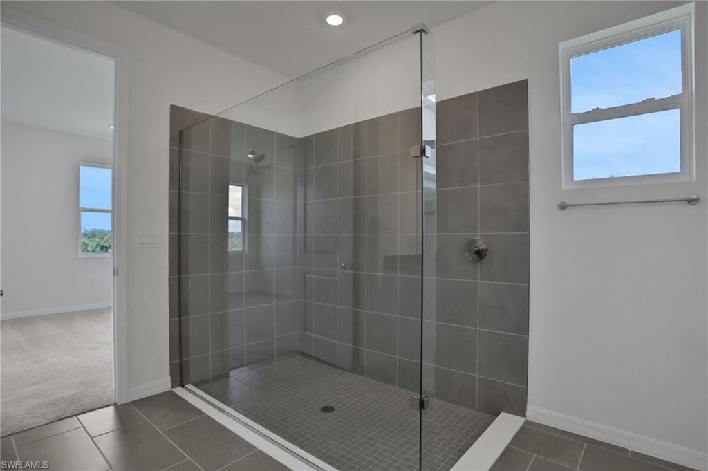Bathroom featuring walk in shower, tile patterned flooring, and carpet flooring