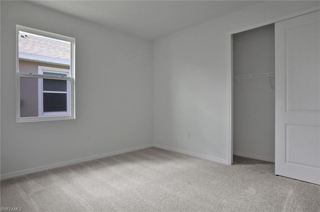 Unfurnished bedroom featuring light carpet and a closet
