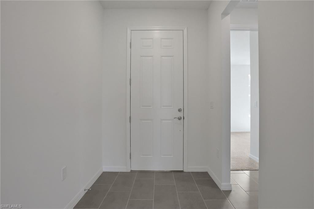 Entrance foyer with baseboards and tile patterned floors