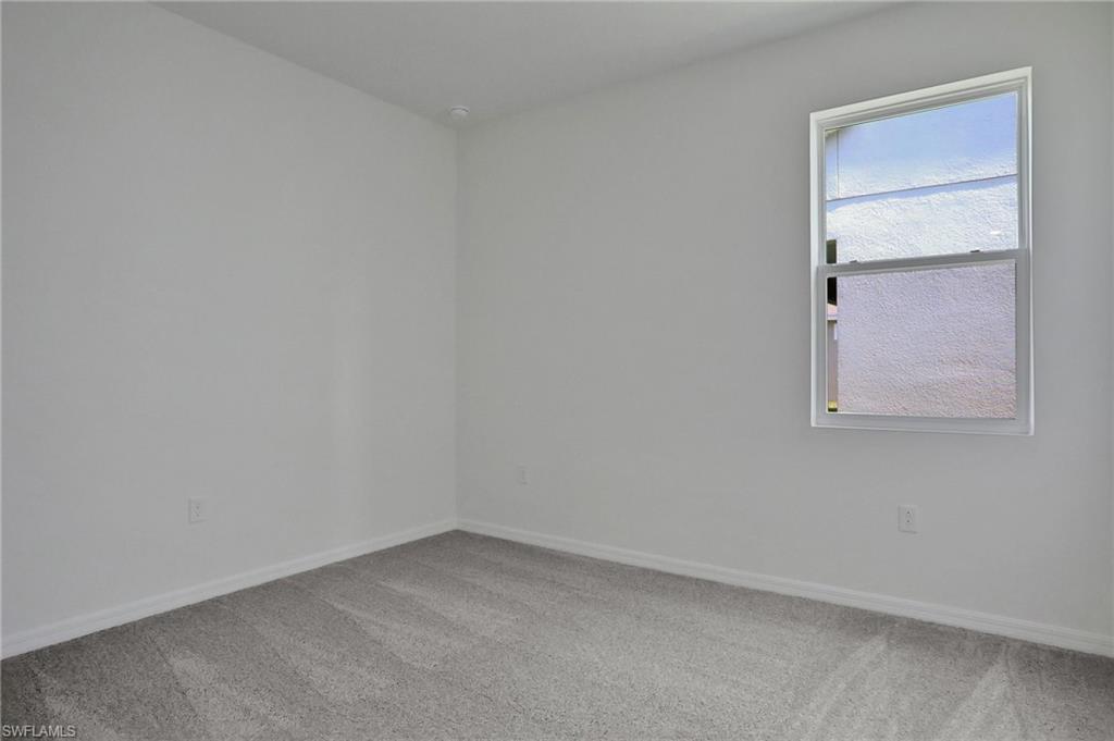 Spare room with light carpet and baseboards