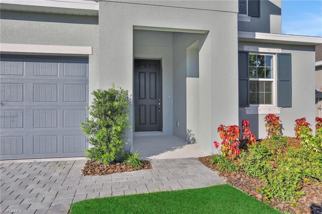 Doorway to property featuring stucco siding and a garage