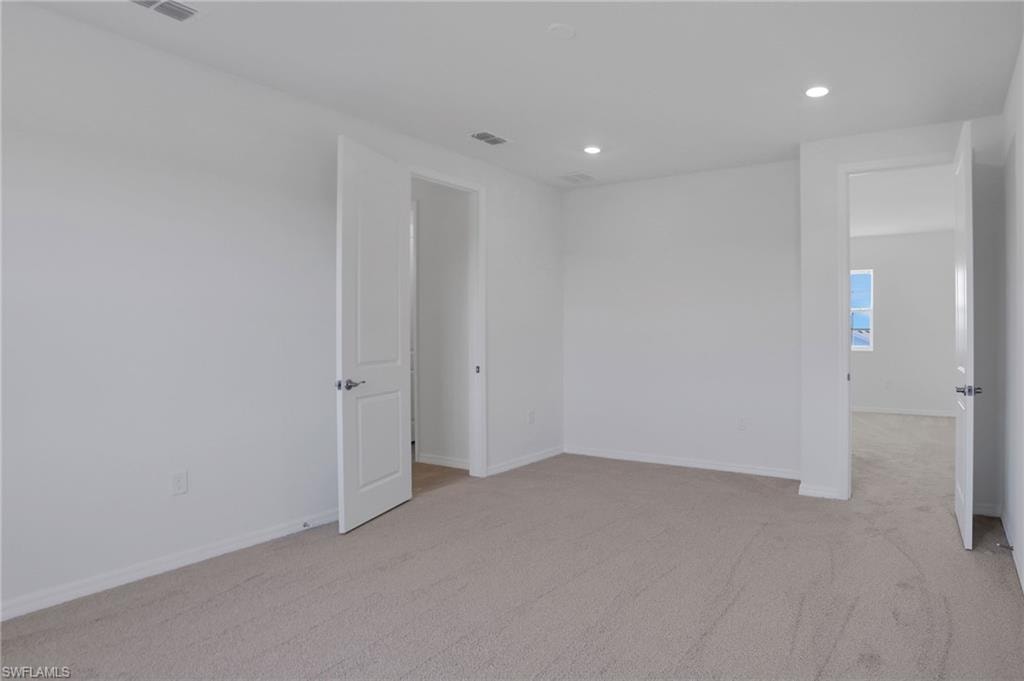 Spare room featuring light carpet and recessed lighting