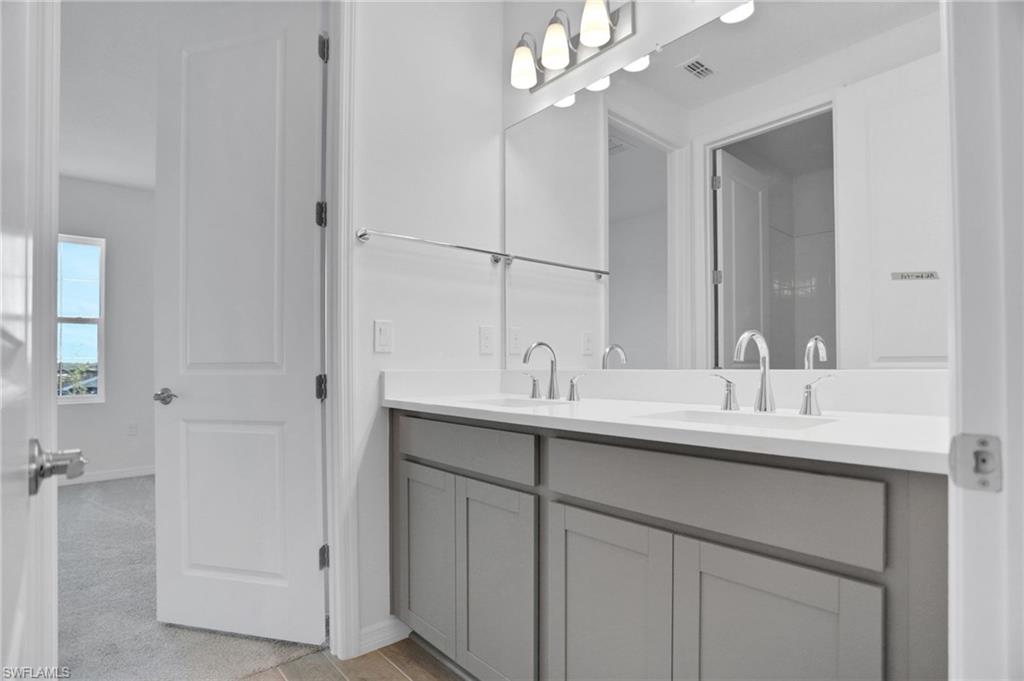 Full bath with double vanity and baseboards
