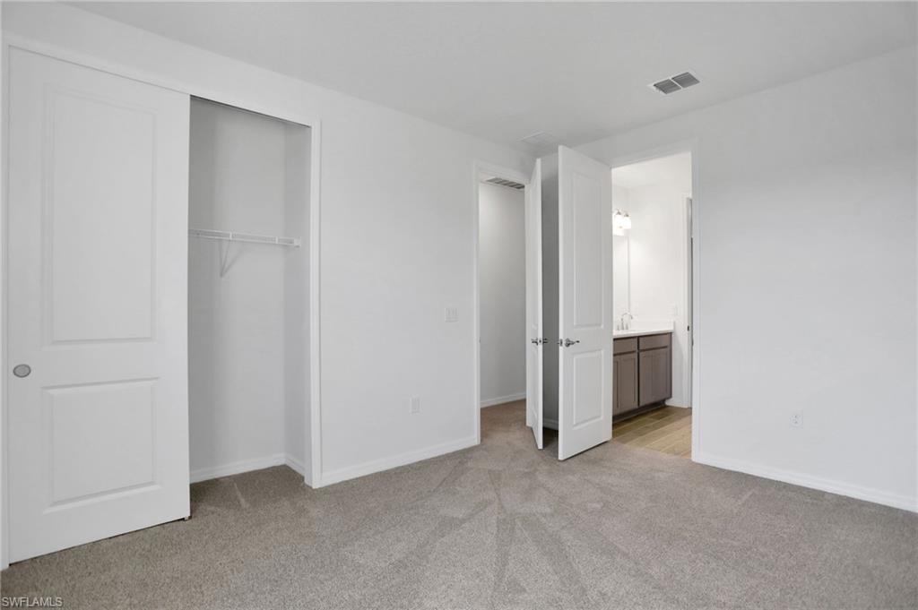 Unfurnished bedroom featuring light carpet and a closet
