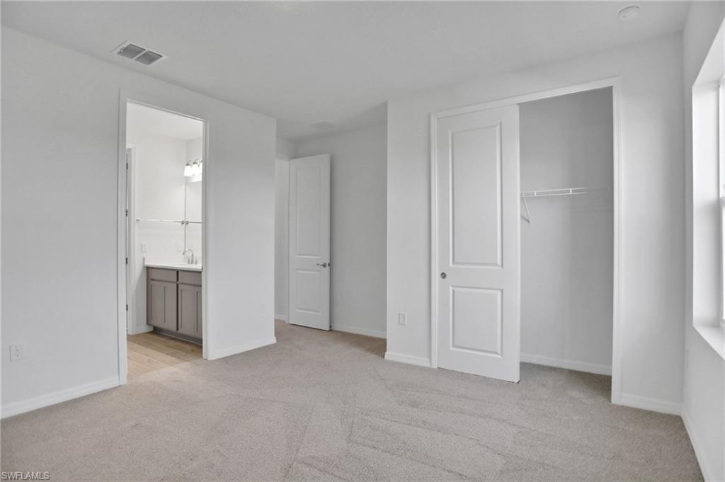 Unfurnished bedroom featuring light colored carpet and a closet