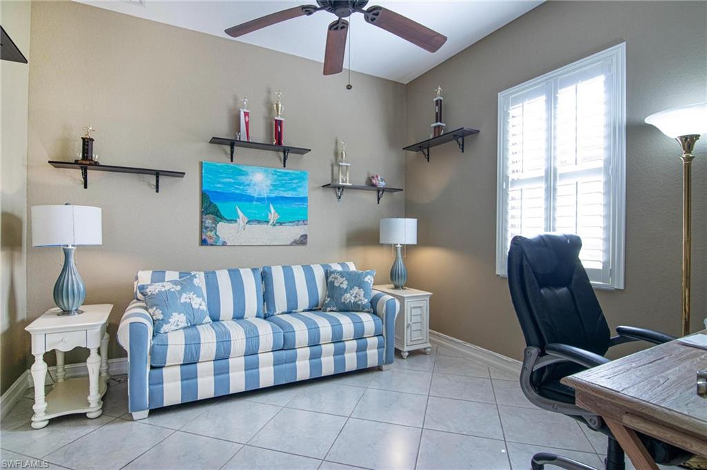 Office area with a ceiling fan and tile patterned flooring