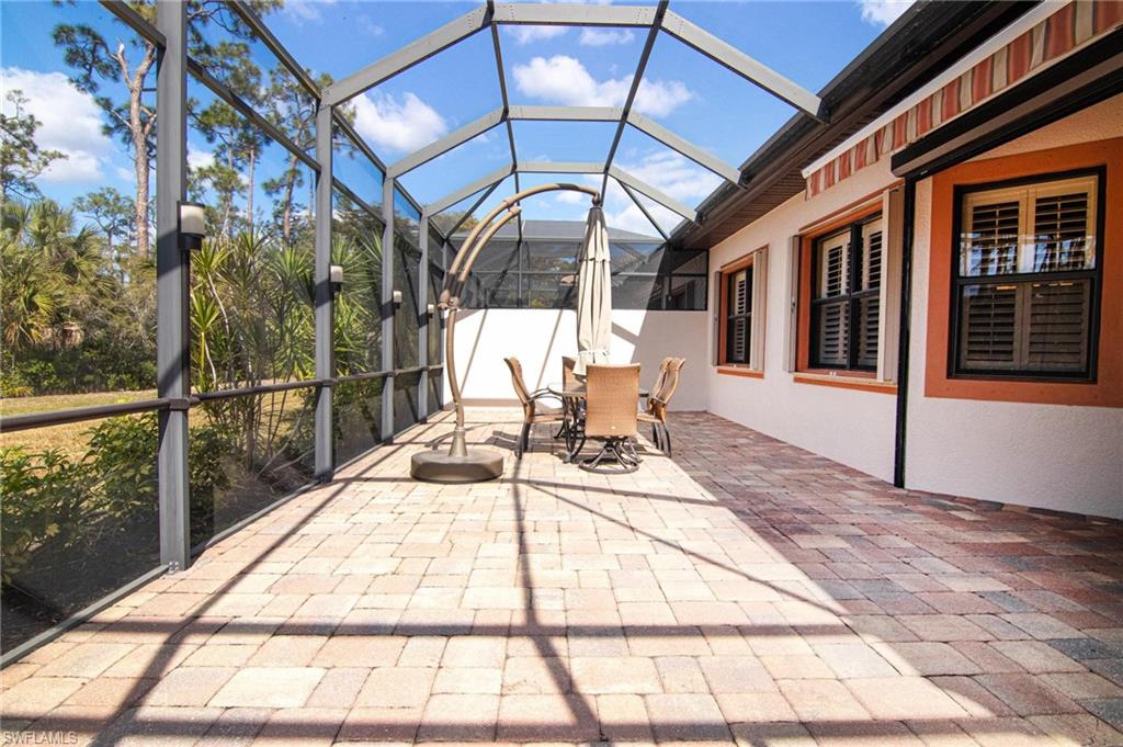 Sunroom / solarium with a patio, outdoor dining space, lofted ceiling, and plenty of natural light