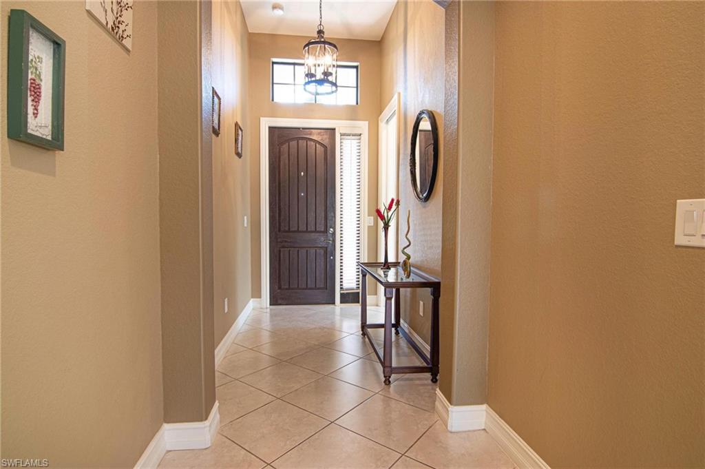 Entryway with tile patterned flooring, a high ceiling, and a chandelier