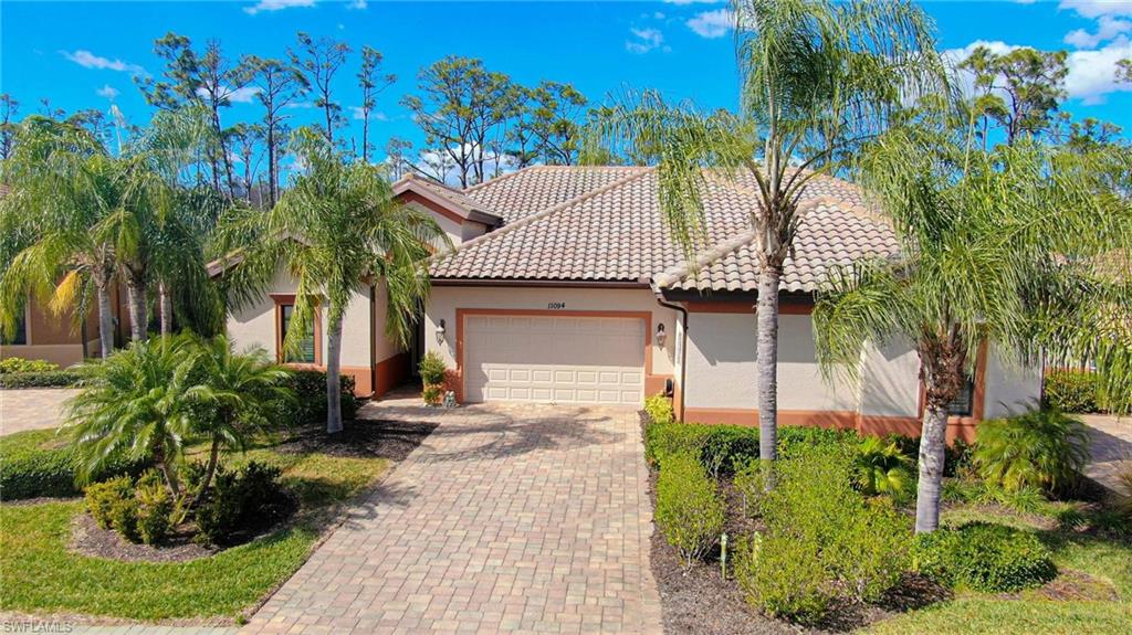 Mediterranean / spanish-style home with a garage, stucco siding, driveway, and a tiled roof