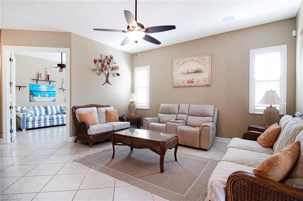 Living room featuring light tile patterned floors and ceiling fan