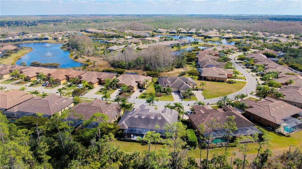 Aerial view of property and surrounding area featuring a nearby body of water and nearby suburban area