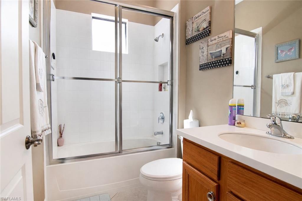 Full bathroom featuring vanity, shower / bath combination with glass door, and tile patterned floors