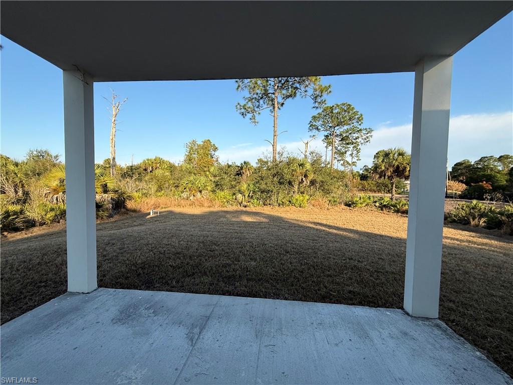 View of grassy yard featuring a patio area