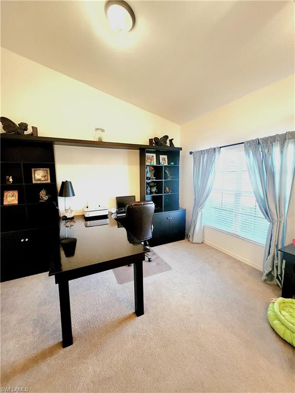 Home office with carpet flooring and vaulted ceiling