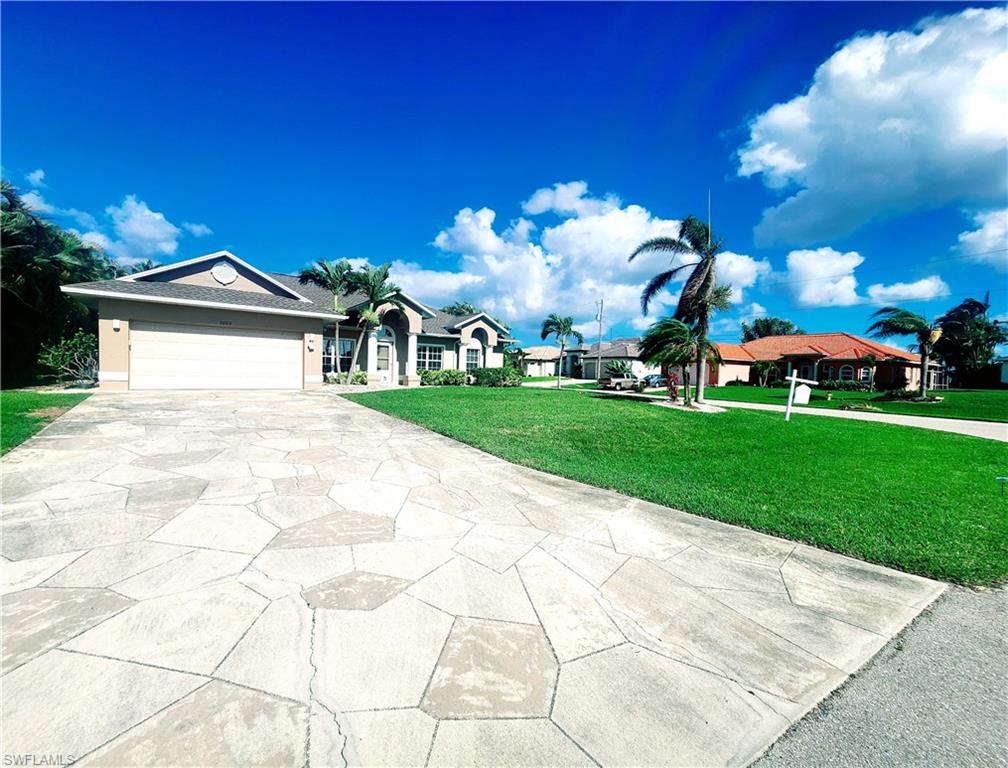 Ranch-style home with a front lawn, concrete driveway, and a garage