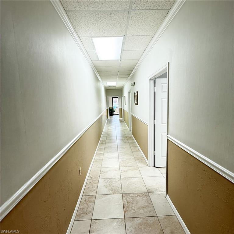 Hall featuring a paneled ceiling and chair rail molding