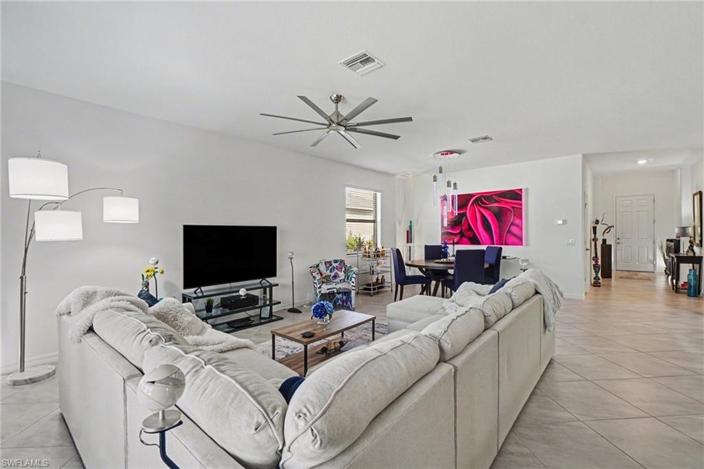 Living room featuring a ceiling fan and light tile patterned floors