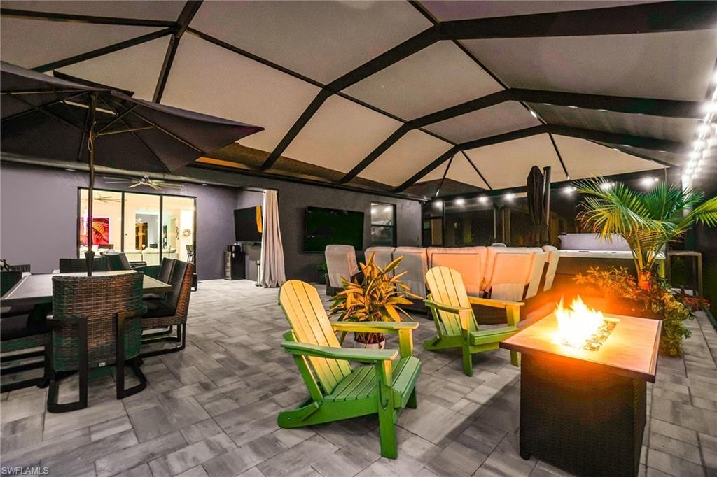 View of patio with a fire pit, an outdoor living / dining area, a lanai, and ceiling fan