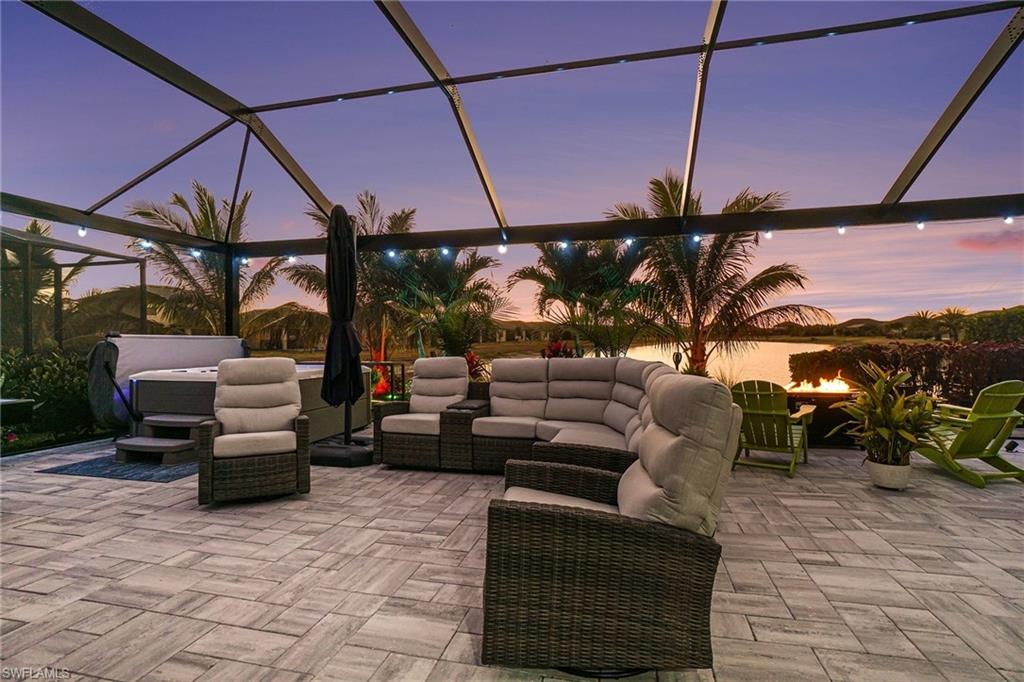 Patio terrace at dusk featuring outdoor seating, a lanai, a sunroom, and a patio
