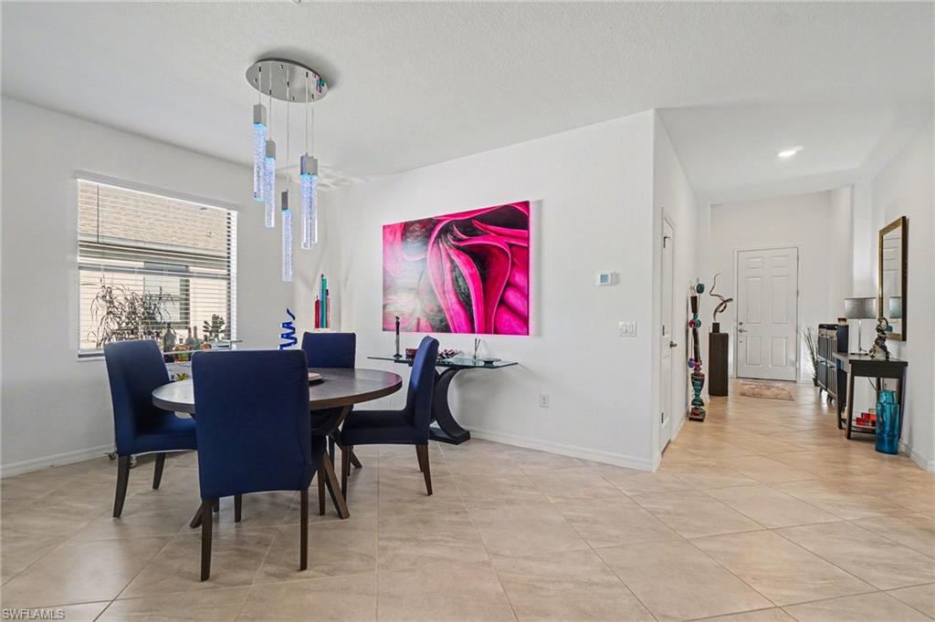 Dining space with baseboards and light tile patterned floors