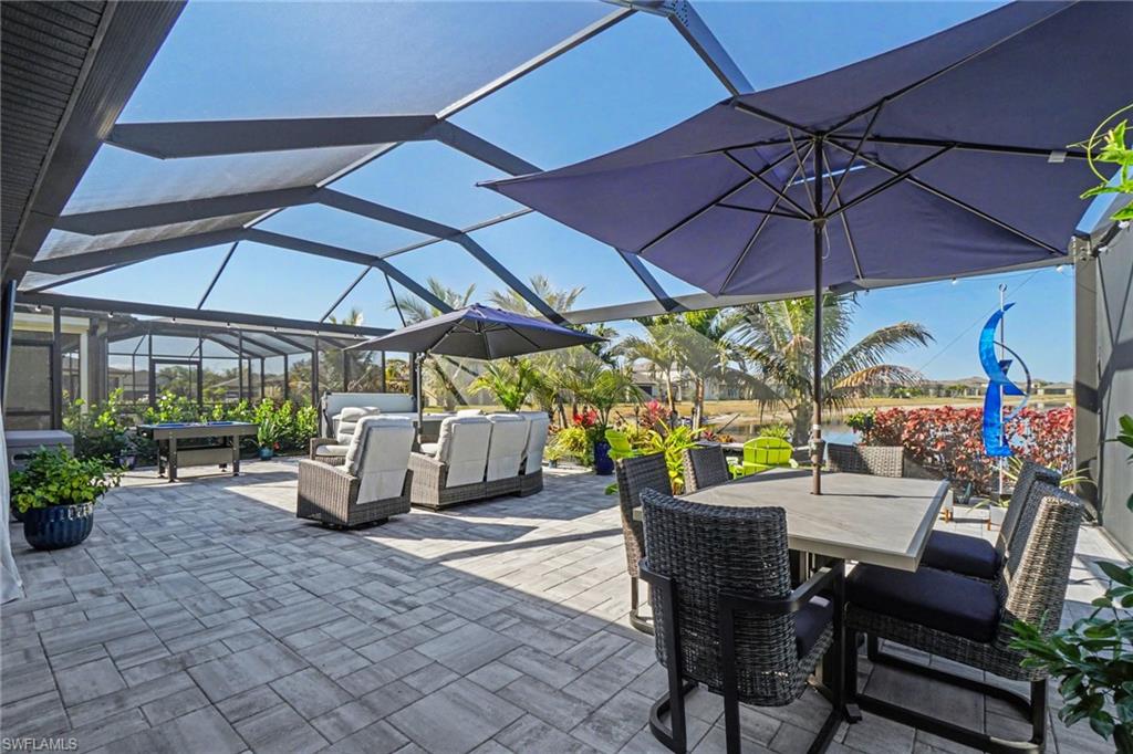 View of patio with a lanai, a sunroom, and outdoor dining area