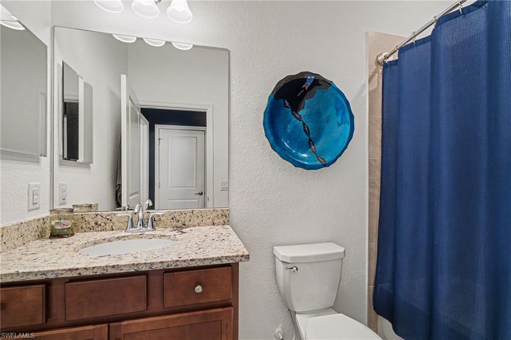 Bathroom with a textured wall and vanity