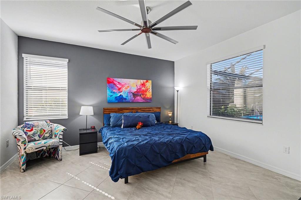 Tiled bedroom featuring a ceiling fan and baseboards