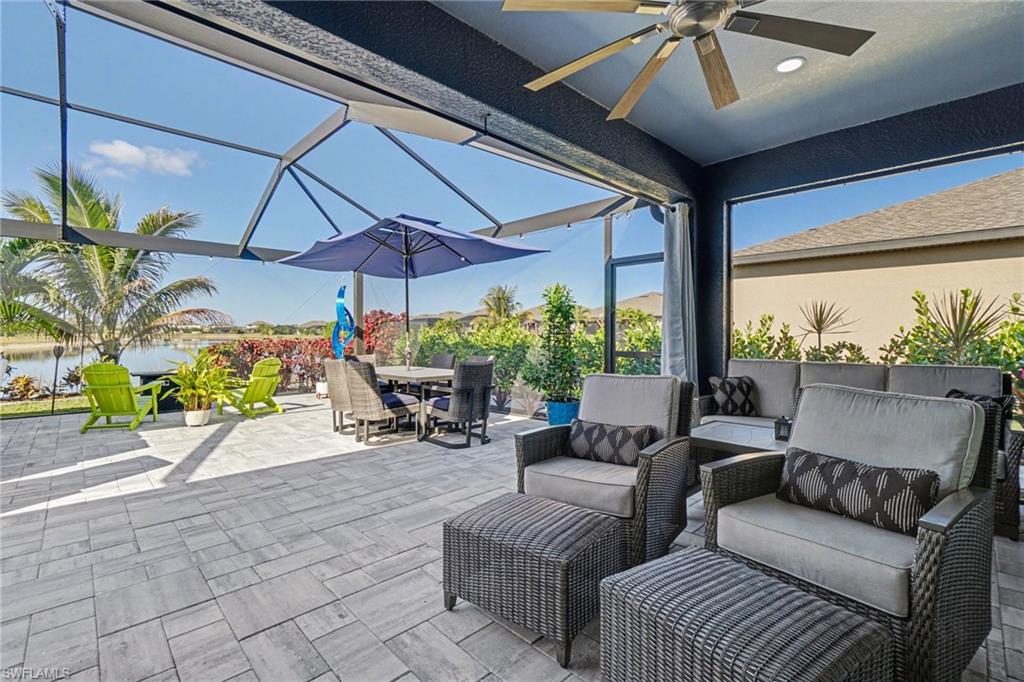 View of patio / terrace with an outdoor living / dining area, a sunroom, a lanai, a water view, and ceiling fan