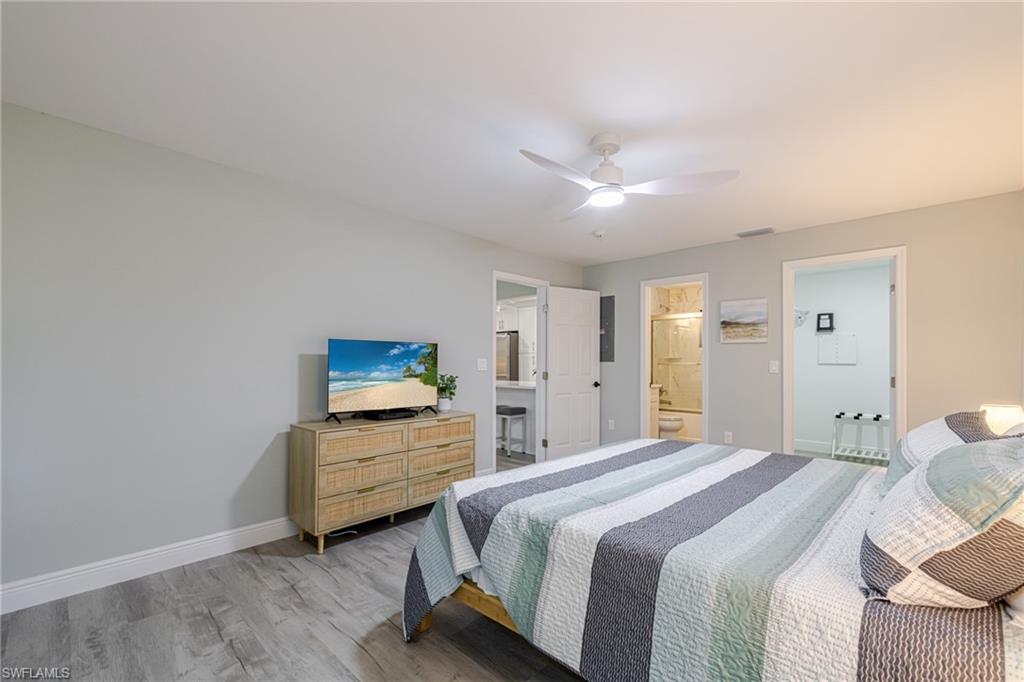 Primary Bedroom featuring wood finished floors, a ceiling fan, and ensuite bathroom