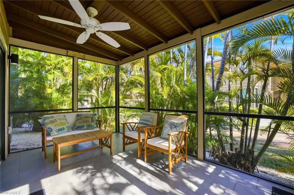 Sunroom with a ceiling fan, beam ceiling, and outdoor furniture