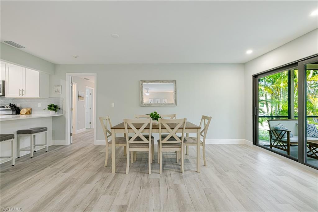 Dining room with light wood finished floors and recessed lighting