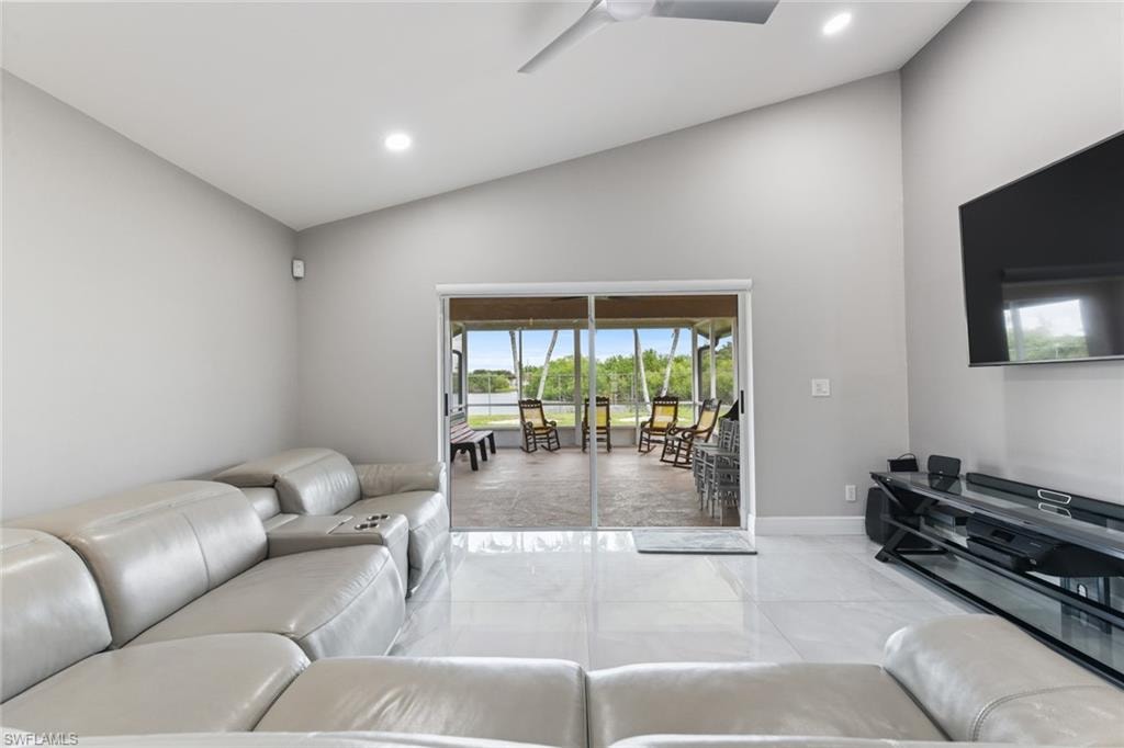 Living room featuring lofted ceiling, a ceiling fan, and recessed lighting